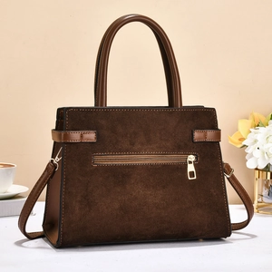 Detail of dark brown faux suede handbag featuring rear zipper pocket and golden hardware