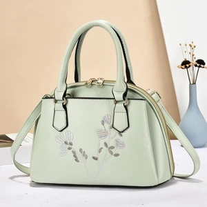 Detailed embroidery on a mint green PU leather handbag with elegant floral patterns