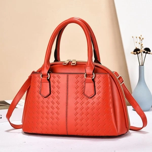 Detail of orange tote bag showing V-weave texture and premium gold zipper hardware