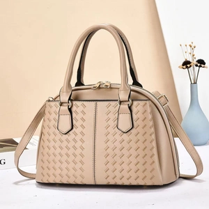 Detailed view of beige woven texture handbag with golden hardware and leather strap