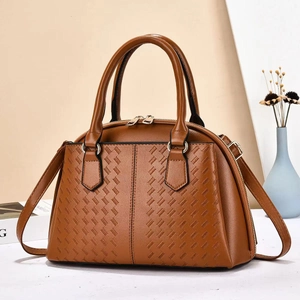 Brown woven tote bag with adjustable strap and golden zipper on white surface