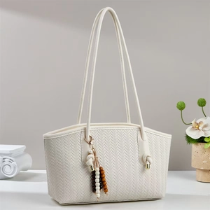 Chic woven tote bag in creamy white with a decorative wooden bead tassel accent