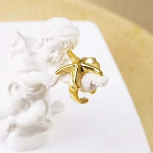 Polished gold starfish open ring on artistic ceramic angel statue for summer beach style