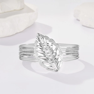 Dettaglio del bracciale rigido a C argento con grande foglia traforata e design intrecciato