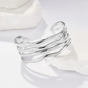 Dettaglio del bracciale rigido ondulato argento con texture martellata a più strati