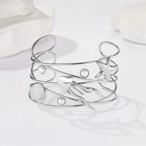 Dettaglio del bracciale argento con ciondoli marini come stelle marine e perle
