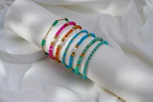 Détail de bracelets perlés colorés avec perles d'eau douce sur support blanc