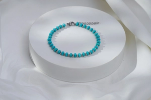 Détails d'un bracelet en perles turquoise avec perles argentées et fermoir mousqueton
