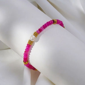 Détail du bracelet à perles roses facettées avec intercalaires dorés et perle blanche
