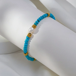 Détail du bracelet en perles d'eau douce et turquoise avec séparateurs dorés sur support