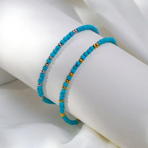 Détail de bracelets en perles turquoise avec perles d'espacement or et argent sur support