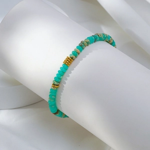 Détail macro du bracelet de perles en turquoise et pierre empereur sur support d'exposition