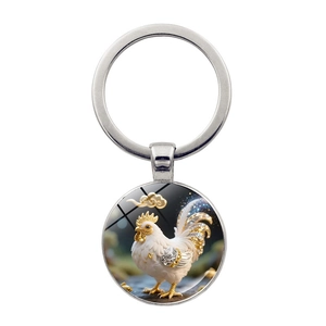 Dettaglio ravvicinato di un portachiavi zodiacale in argento con cabochon gallo bianco
