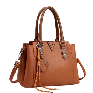 Brown textured leather tote bag with metal V-decoration and woven strap detail