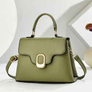 Detailed view of olive green pebbled leather bag with gold buckle and textured finish
