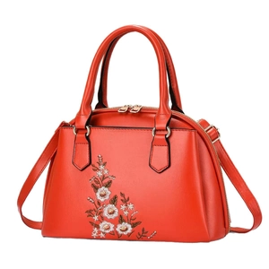 Elegant red faux leather handbag with white floral embroidery and gold hardware accents