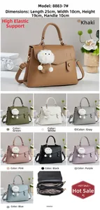 Detail showing high-capacity leather handbag with lychee texture and plush monster charm