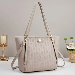 Detail of embossed lychee leather tote bag with vertical stripes and gold hardware