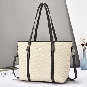 Detail of minimalist tote bag with woven texture, leather trim and detachable shoulder strap