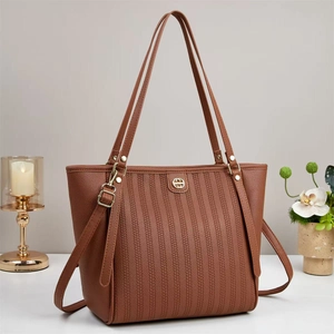 Close-up of vertical embossed texture and golden logo on brown vintage tote bag