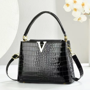 Elegant black crocodile pattern handbag with gold V-buckle and detachable strap