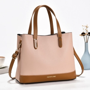 Detail of pink and brown leather tote bag with Fashion & Bag text and adjustable strap