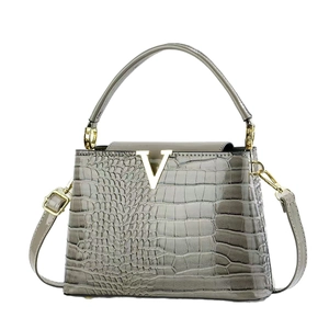 Elegant grey crocodile pattern trapezoid handbag with gold V logo and crossbody strap