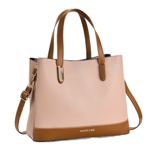 Pink lychee grain leather tote bag with brown handles and gold hardware on white background