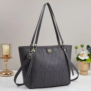 Détails macro du sac cabas gris foncé avec motifs de cœurs embossés et logo en métal