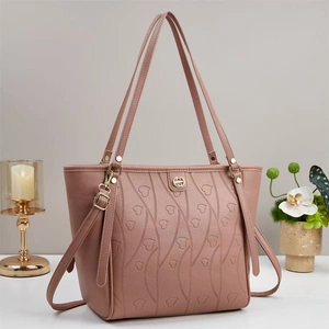 Détail du sac cabas rose avec motifs de cœur gaufrés et finitions de couture ondulées