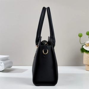 Side view of black pebble leather tote bag showing gold D-ring and zipper detail