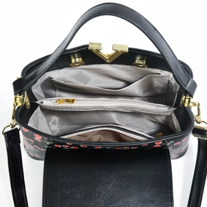 Detailed top view of a cherry print bucket bag interior with multiple compartments