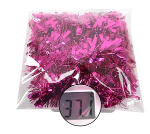 Detailed macro view of 2m rose pink tinsel garland on scales weighing 37.1g