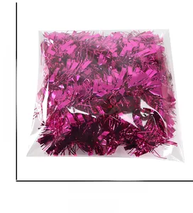 Close-up of rose red tinsel garland party decoration in transparent packaging