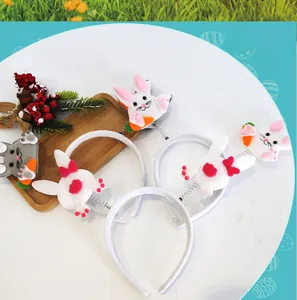 Detail view of Easter plush headbands with rabbit and carrot spring accents on a white tray