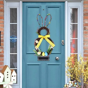 Easter bunny rattan wreath with yellow bow and colorful eggs on a blue front door