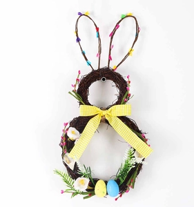 Detail van een paashaaskrans van rotan met gele strik en gekleurde paaseitjes