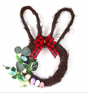 Detail of Easter bunny rattan wreath featuring a buffalo plaid bow and colorful speckled eggs