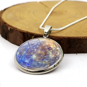 Makroansicht der Galaxie-Halskette mit Planetenmuster auf einer Holzscheibe