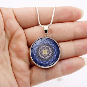 Detail of silver snake chain with round blue mandala flower art glass pendant