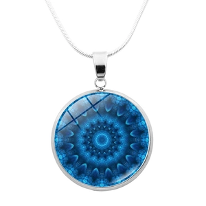 Detail of silver mandala pendant with intricate blue geometric art on a snake chain necklace