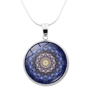 Macro shot of silver mandala pendant with deep blue glass cabochon on snake chain