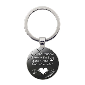 Detail of silver teacher keychain with inspirational quote under polished glass cabochon