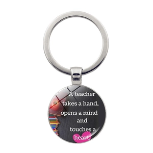 Macro view of teacher gift keychain with glass gem and inspirational quote on white background