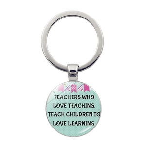 Detail of silver teacher keychain with inspirational quote on green polka dot background