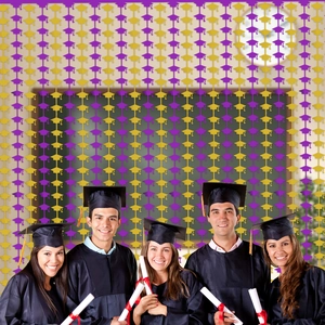 Graduation party fringe curtain backdrop with purple and gold mortarboard decorations