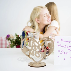 Macro detail of laser-cut wooden Love MOM heart ornament with natural grain finish
