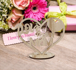 Detail of wooden heart ornament with Love you MOM engraving on floral background