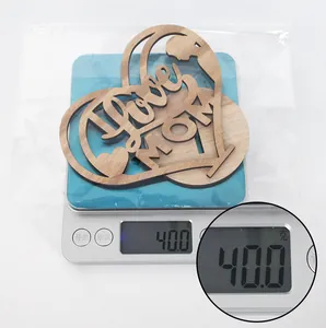 Wooden Mother's Day heart ornament weighing 40g in packaging on a digital scale