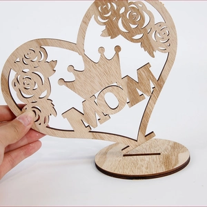 Close-up of wooden MOM heart ornament with laser-cut roses and crown details